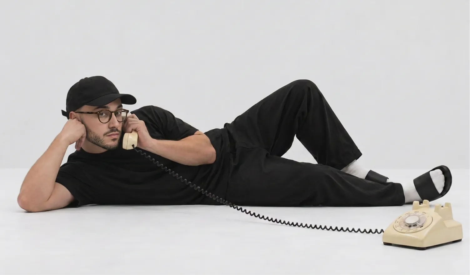 Sofiane lying on the floor, chatting on a vintage rotary phone